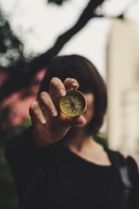 photo of woman holding compass